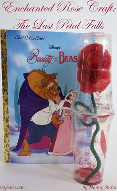 the beauty and the beast book is next to a vase with roses in it,