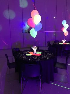 the table is decorated with balloons and streamers