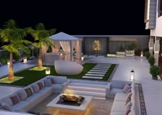 an outdoor living area at night with couches, tables and palm trees in the foreground