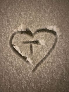 a heart is drawn in the snow with an arrow on it's left side