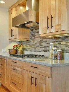 a kitchen with wooden cabinets and stainless steel range hood