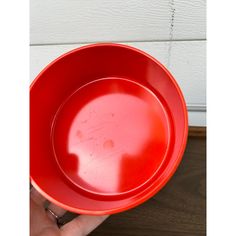 a person holding a red bowl in their hand