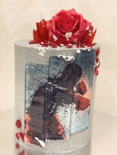 a red rose sitting on top of a frosted cake