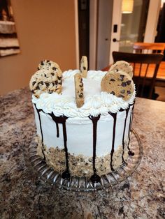 a frosted cake with cookies and chocolate drizzles on the icing