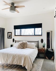 a bedroom with a bed, dresser and ceiling fan