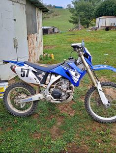 a blue dirt bike parked in the grass