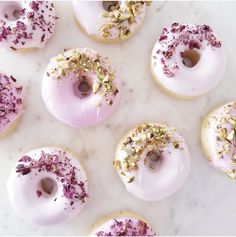 there are many donuts with pink frosting and sprinkles on them