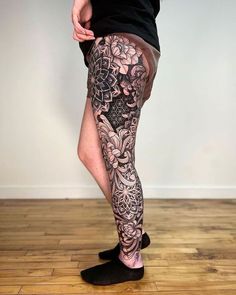 a person with tattoos on their legs and leggings is standing in front of a wall