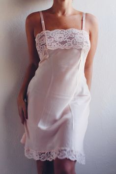 This exquisite nightgown features a sheer lace bust that adds a touch of romance and sophistication, making it an ideal choice for warm, light summer nights. Crafted from high-quality vintage fabric, this pink lace slip is designed to provide both comfort and style. The pale pink hue exudes a soft, feminine allure, while the sheer lace detailing on the bust creates a captivating and delicate look. Whether you're lounging at home or looking for a charming addition to your vintage lingerie collect Lace Slip Dress For Sleep, Elegant Spring Nightgown For Bedtime, Feminine Sleeveless Delicate Lace Sleepwear, Feminine Delicate Lace Sleeveless Sleepwear, Feminine Sheer Dresses For Loungewear, Feminine Sheer Lounge Dress, Coquette Lace Trim Slip Dress For Night, Feminine Camisole Slip Dress With Delicate Lace, Delicate Lace Coquette Sleepwear For Loungewear