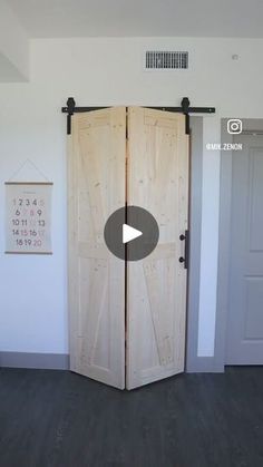 an open wooden door sitting inside of a living room next to two doors with black handles