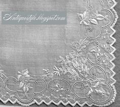 an embroidered white cloth with flowers and leaves on the edge, in black and white