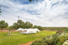 a white tent set up in the middle of a field