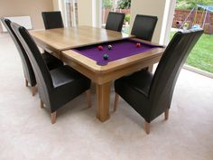 a dining room with a pool table and chairs