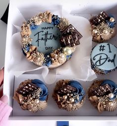 a box filled with cupcakes covered in frosting and decorated to look like father's day