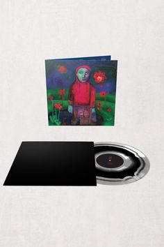 a cd with an image of a man standing next to flowers