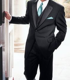 a man in a suit and tie leaning against a wall with his hand on the door