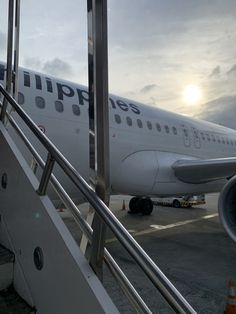 an airplane sitting on the tarmac with stairs leading up to it's door