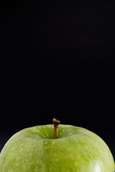 a green apple sitting on top of a table