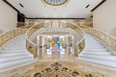 a large foyer with marble floors and white railings