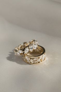 two gold wedding rings sitting on top of each other