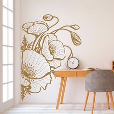 a desk with a chair, clock and flower wall decal