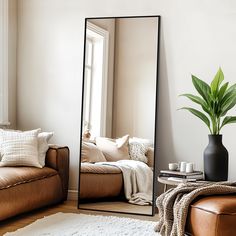 a large mirror sitting next to a couch in a living room