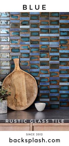 a wooden cutting board sitting on top of a counter next to a blue tile wall