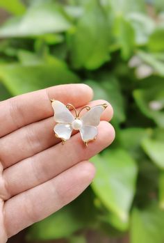 Embrace the beauty of nature with our Freshwater Pearl Mother of Pearl Butterfly Brooch. This exquisite piece features delicate wings crafted from shimmering mother of pearl and is beautifully accented with a lustrous freshwater pearl at the center. The gold-plated copper adds a touch of elegance, making it a stunning accessory for any occasion. Measuring approximately 1.1 in * 1 in, this butterfly brooch is perfect for adding a whimsical yet sophisticated touch to your outfit. Whether worn on a Elegant White Enamel Pin For Gift, Wedding Enamel Pin Brooch, White Brooch Jewelry Gift, White Butterfly Brooches For Gifts, Handmade White Wedding Pins, Handmade White Brooches For Anniversary, Dating Gifts, Pearl Butterfly, Women Bride