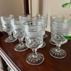 six glass goblets are lined up on a table