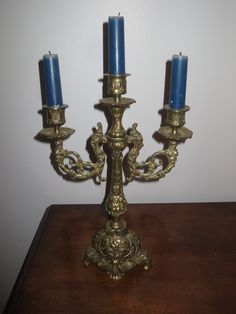 three blue candles sitting on top of a wooden table