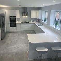 an empty kitchen with two stools next to the counter