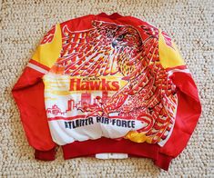 a red and yellow hawks jacket laying on the floor