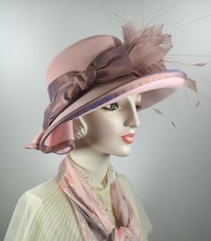 You'll look great in this pretty pink wool felt hat! It can easily transition from Winter to early Spring and is perfect for any dressy occasion. Imagine walking into church with this beauty! The flattering asymmetrical wide brim hat turns up on the left and slopes down on the right. A unique folded pleat adorns the brim. It's topped with a gorgeous mauve/pink band and bow. This hat that will be the envy of everyone who see it! The hat itself is pink wool felt and the crown (top) is slightly dom Spring Hat, Spring Hats, Dupioni Silk, Church Hats, Pink Feathers, Felt Hat, Wide Brimmed Hats, Brim Hat, Early Spring