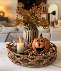 a pumpkin sitting in a basket next to a candle