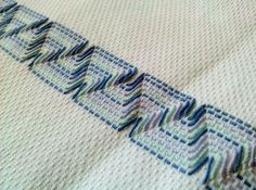 a close up view of a blanket with blue and green designs on the edges,