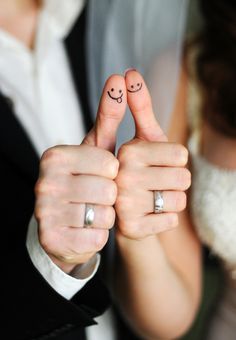 two fingers with smiley faces drawn on them