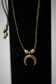 a gold necklace on a black display stand