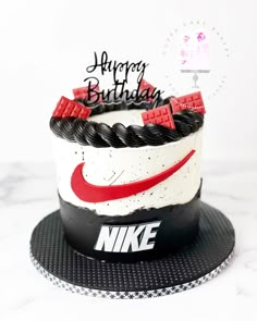 a birthday cake with the nike logo on it and happy birthday written in black, white, and red