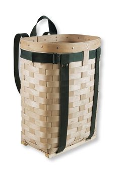 a woven basket with black straps on the front and bottom, sitting against a white background