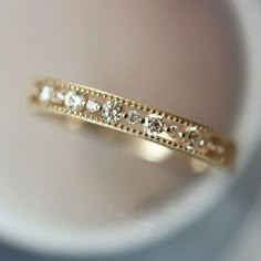 a close up view of a gold ring with diamonds