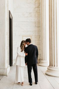 a bride and groom are standing in front of the columns at the lincoln memorial, kissing