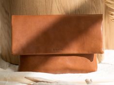 Tan brown leather clutch. Handmade designer clutch made of vegetable-tanned leather. The simple design of this bag lets the women feel unique and stylish and perfectly fits with all outfits.  We use carefully selected genuine vegetable tanned leather from Italian (Tuscany) manufacturers.  Below there are some more detailed features of the backpack: * The dimensions of the bag are 16.7 x 7.9 x 0.8 in (17 x 20 x 2 cm). * There is one section inside. * The color of the bag is brown. * Soft leather. Modern Leather Clutch With Smooth Grain, Leather Clutch With Leather Handles, Modern Leather Clutch For Everyday, Modern Everyday Leather Clutch, Versatile Leather Clutch With Smooth Grain, Minimalist Leather Clutch With Removable Pouch, Minimalist Leather Clutch For Everyday Use, Minimalist Soft Leather Clutch For Daily Use, Chic Daily Use Clutch With Smooth Grain