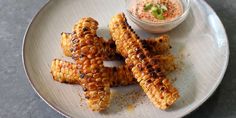 grilled corn on the cob with a small bowl of dip