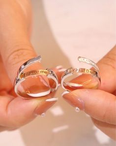 two rings with words on them being held by someone's hands