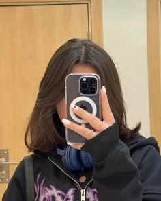 a woman taking a selfie in front of a mirror with her phone up to her face