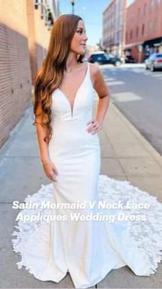 a woman is standing on the sidewalk in a white dress and posing for a photo