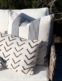 two black and white pillows sitting on top of a chair