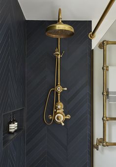 a shower head and hand held shower faucet in a bathroom with herringbone tile