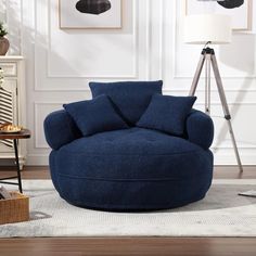 a blue chair sitting on top of a wooden floor next to a lamp and rug