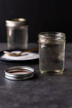 a glass jar sitting on top of a table next to a plate